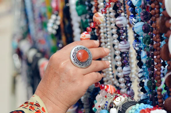 Frau wählt Schmuck in Reihe von Halsketten und Armbändern — Stockfoto