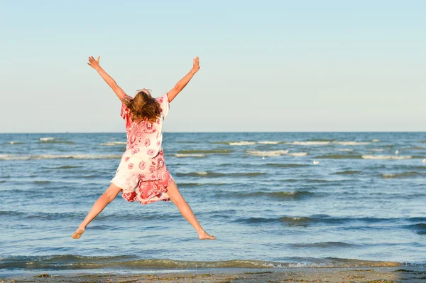 Ung glad kvinna hoppa högt på seaside — Stockfoto