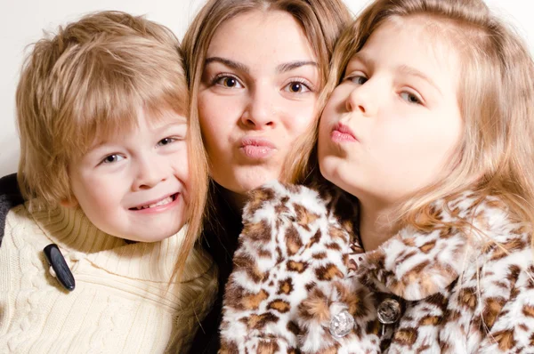 Three happy brother and sisters hug