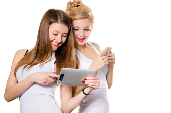 Zwei glückliche Frauen, die auf Tablet-PC schauen und lächeln — Stockfoto