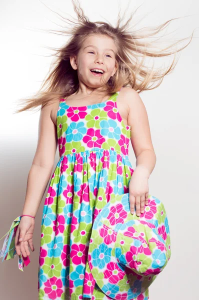 Kleine school meisje op zoek verrast en haar geblazen met wind — Stockfoto