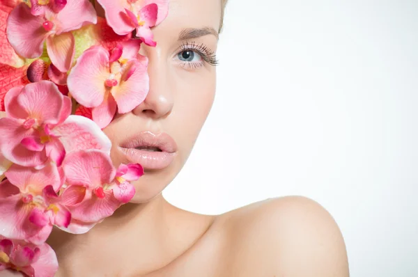 Beautiful girl face & pink flowers, perfect skin and lips on white copyspace — Stock Photo, Image