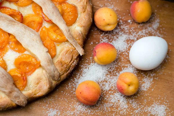 Homemade apricot pie closeup with fresh fruit and egg — Stock Photo, Image