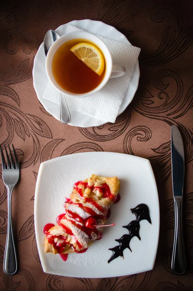 Apple croissant and black tea with lemon — Stock Photo, Image