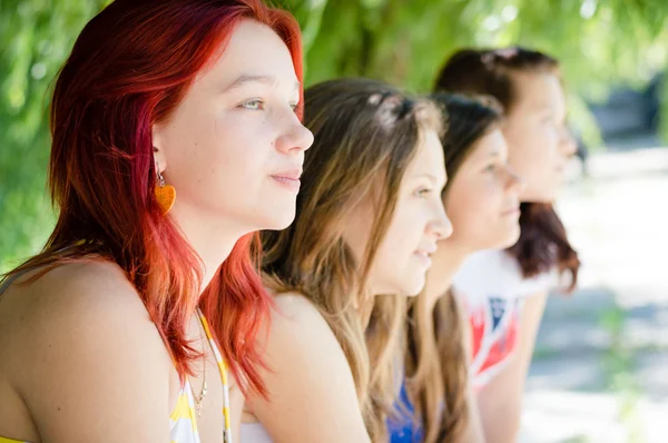 Quatro feliz adolescente menina amigos olhando juntos em uma direção — Fotografia de Stock