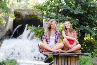 Yoga pozisyonda oturan iki genç kız