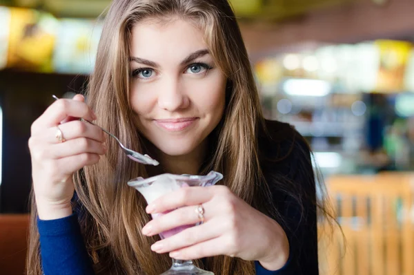 Fiatal csinos lány eszik fagylaltot, kávézó — Stock Fotó
