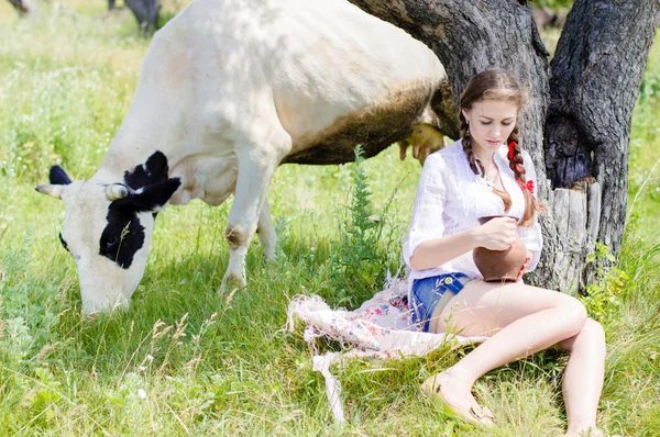 年轻女人坐累了附近农村的牛 — 图库照片