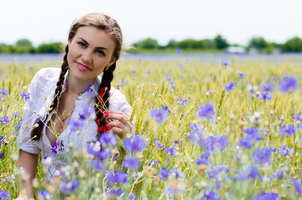 年轻漂亮的女人走在绿色小麦字段在夏季的一天 — 图库照片