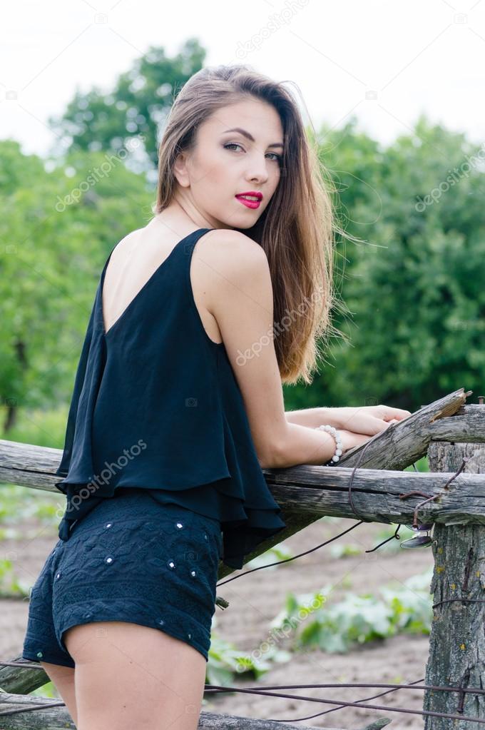 Beautiful sensual fashion woman at old country fence