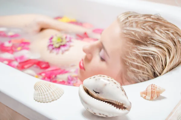 Красивая леди принимает ванну с лепестками цветов — стоковое фото