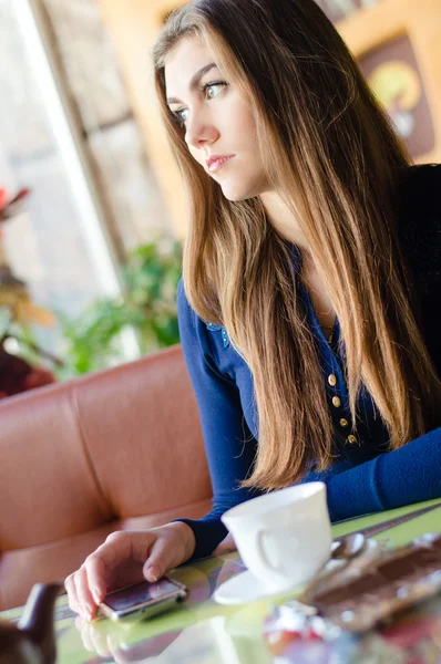 Όμορφη νεαρή γυναίκα που κάθεται μόνη σε café περιμένοντας τηλεφώνημα — Φωτογραφία Αρχείου