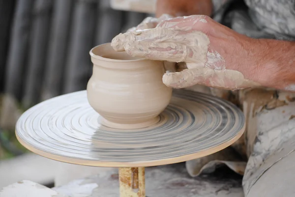 Artesano haciendo jarrón de arcilla húmeda fresca en la rueda de cerámica — Foto de Stock