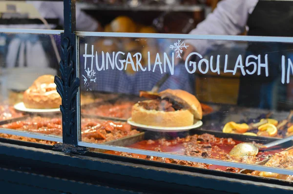 Goulash soep met rundvlees, aardappel en vlees worst, geserveerd in een brood kom — Stockfoto