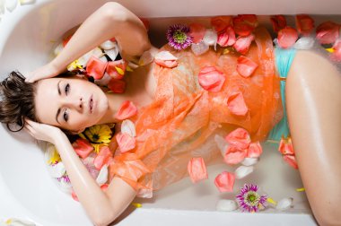 Kadın süt banyosu çiçekler içinde dinlendirici