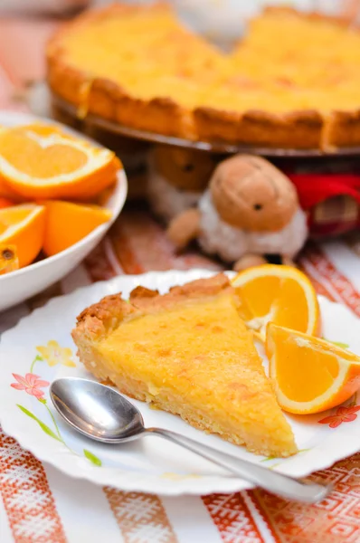 Piece of Lemon and almond pie on plate with oranges — Stock Photo, Image