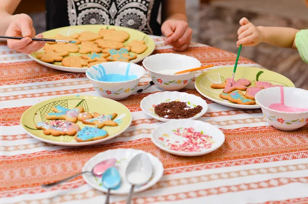 Close up little hands decorating the gingerbread cookies — Stock Photo, Image