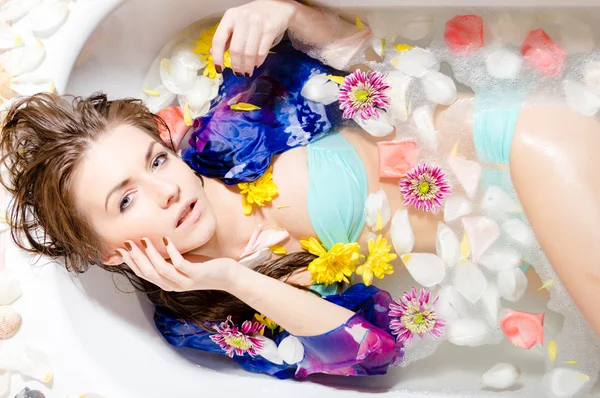 Леди принимает ванну с лепестками цветов — стоковое фото