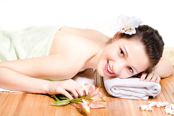 Frau entspannt sich bei Massage mit Blumen — Stockfoto