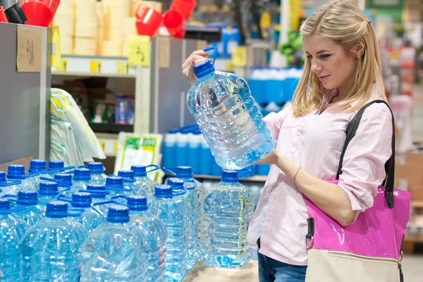 女性は、水のボトルを買う — ストック写真