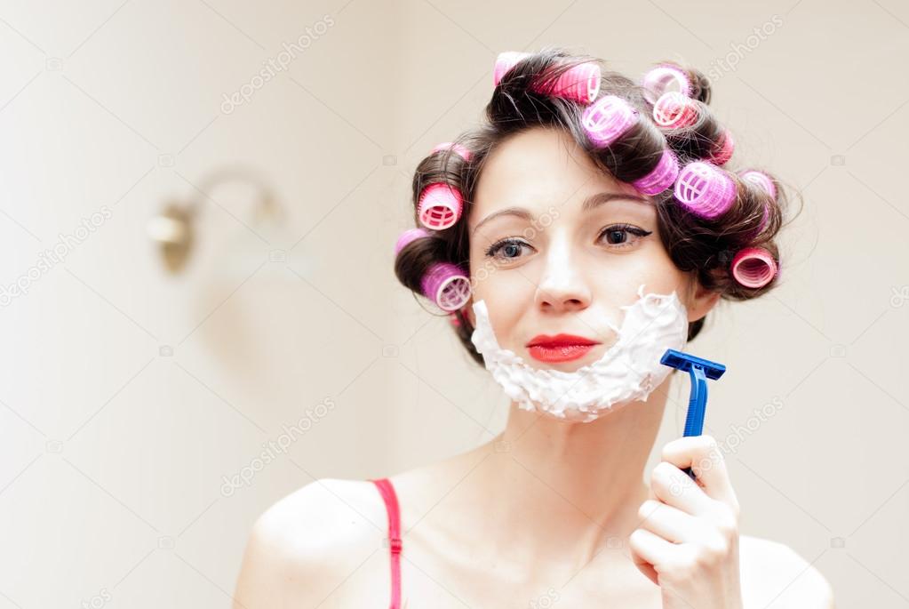 Girl shaving with foam & razor her face