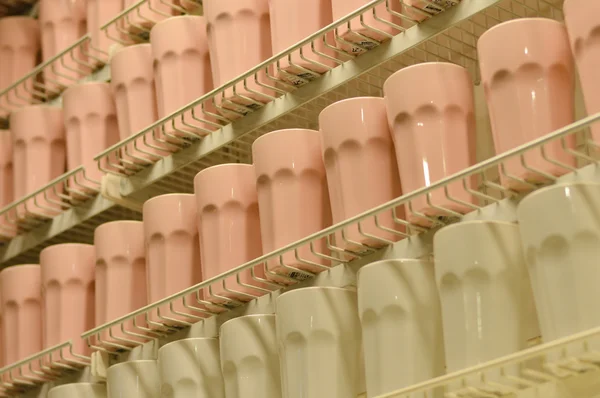 Beaucoup de tasses de couleur claire sur l'étagère — Photo