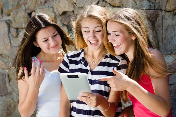 Tre flickor vänner tittar på TabletPC — Stockfoto