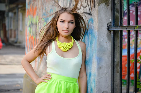 Hermosa mujer de moda con estilo en la pared de graffiti en la ciudad con el pelo volador —  Fotos de Stock