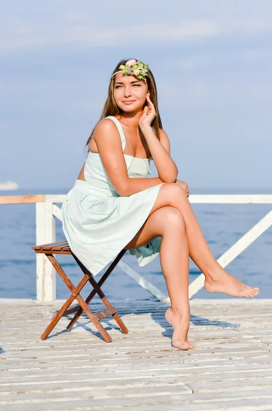Joven hermosa mujer de moda elegante sentado en el muelle del mar — Foto de Stock