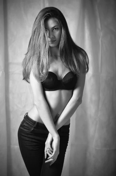 Young woman posing in bra & jeans — Stockfoto