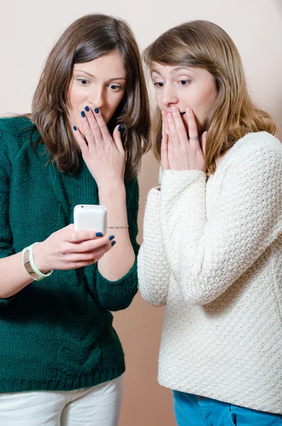 Frauen lächeln glücklich aufs Handy — Stockfoto