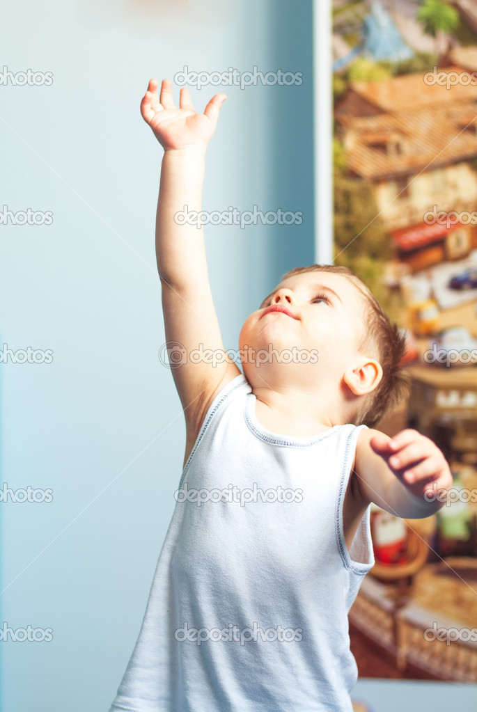 Little boy toddler reaching up at home