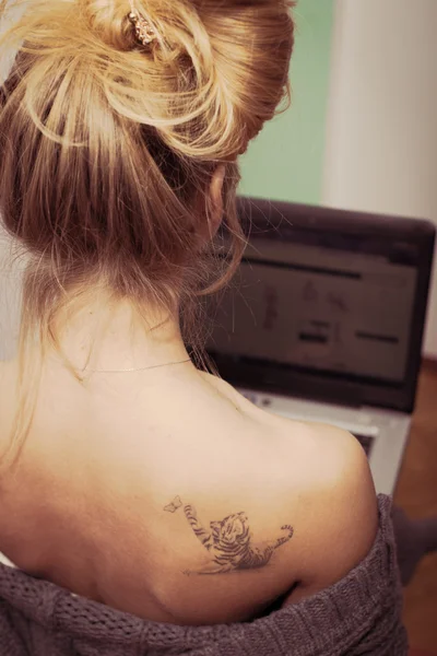 Woman with tattoo  working on laptop — Stock Photo, Image