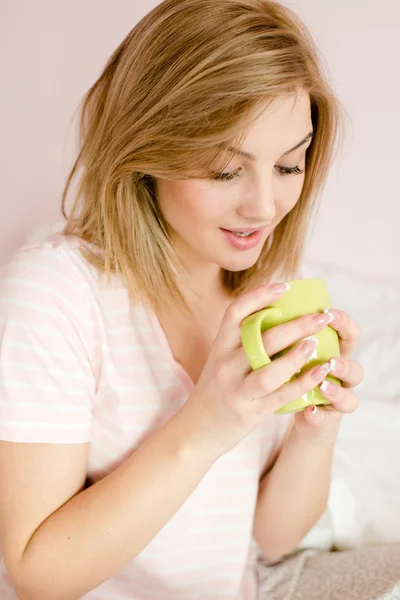 Женщина смотрит на чашку горячего напитка — стоковое фото