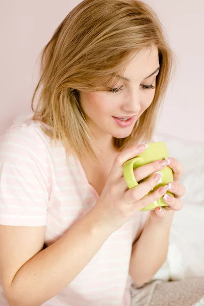 Mujer mirando una taza de bebida caliente — Foto de Stock