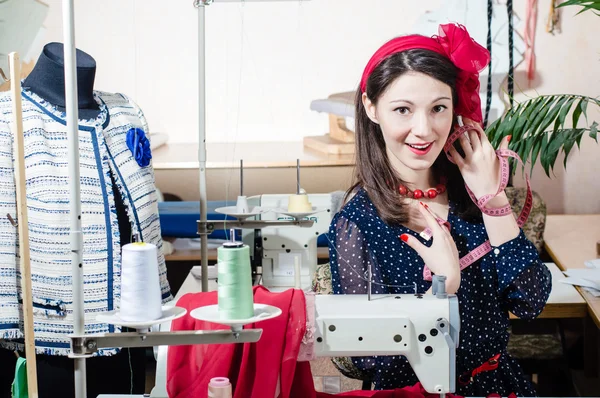 Divertido joven pinup mujer con máquina de coser y cinta métrica — Foto de Stock