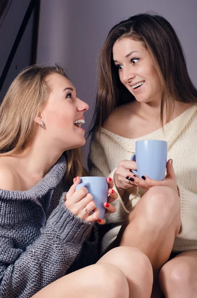 Donne in maglioni che sorridono e bevono bevande — Foto Stock