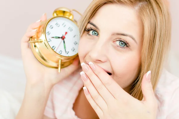 Girl with sleepy face and an alarm clock — Stock Photo, Image