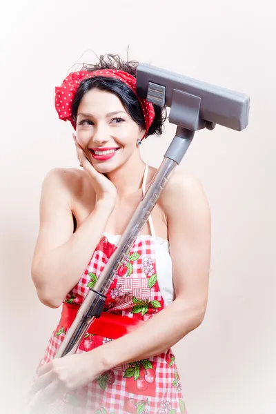 Charming funny young cute pretty woman pinup girl standing with vacuum cleaner and gently smiling on white background — Stock Photo, Image