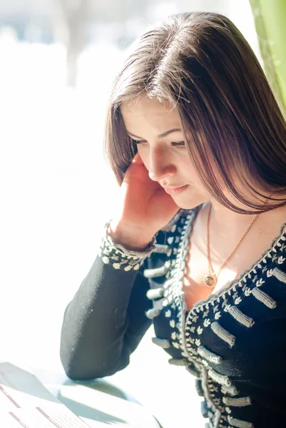 Vrouw zitten in een cafe met een menu-boek — Stockfoto