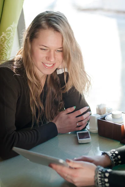 Mädchen im Café schaut auf Tablet-Computer — Stockfoto