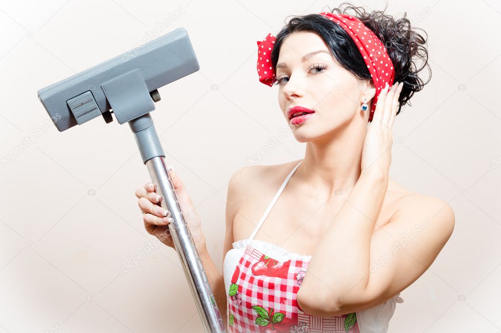 Closeup portrait on funny charming young beautiful brunette woman pin-up girl with vacuum cleaner raised in hand straightens her hair
