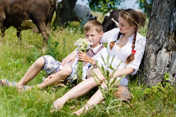 Garçon et belle jeune fille avec des vaches — Photo