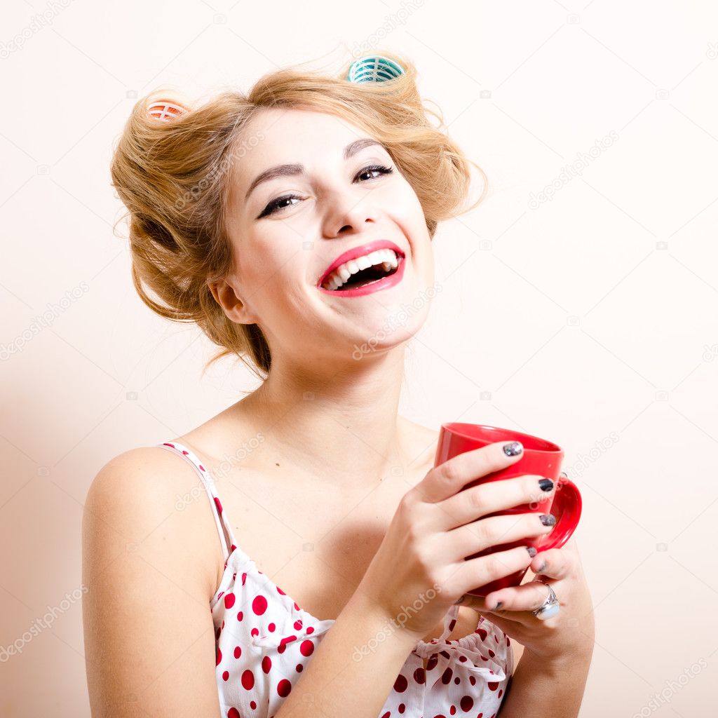 Beautiful blond funny pinup green eyes blond woman with curlers happy smiling looking at camera drinking tea & having fun