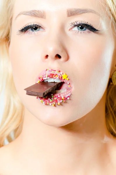 Woman with color sweet lips eating chocolate — Stock Photo, Image