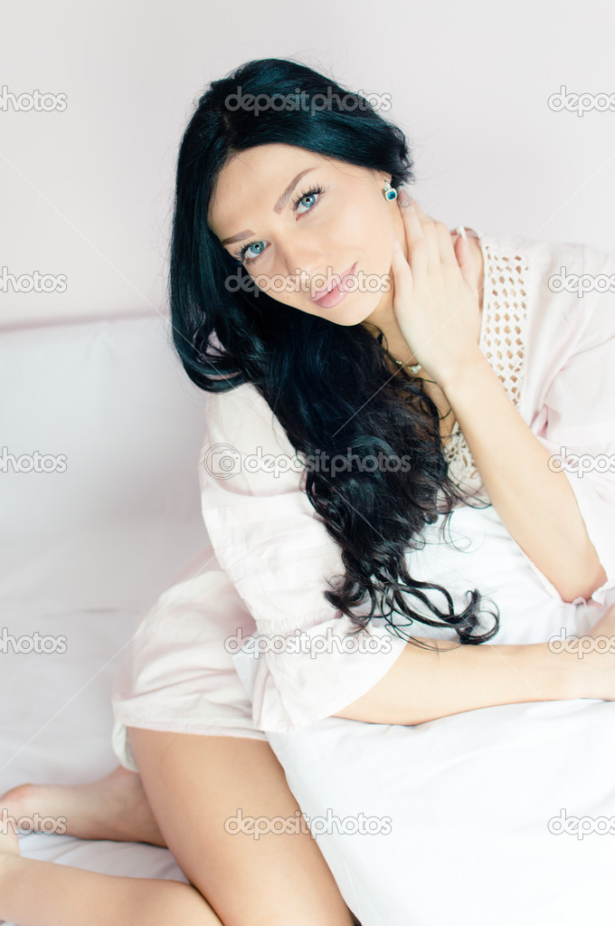 Woman sitting in bed holding pillow