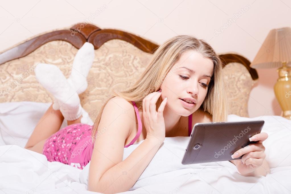 Woman  with tablet pc computer  lying on bed