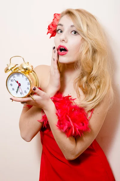 Mulher de vestido vermelho segurando despertador-relógio — Fotografia de Stock