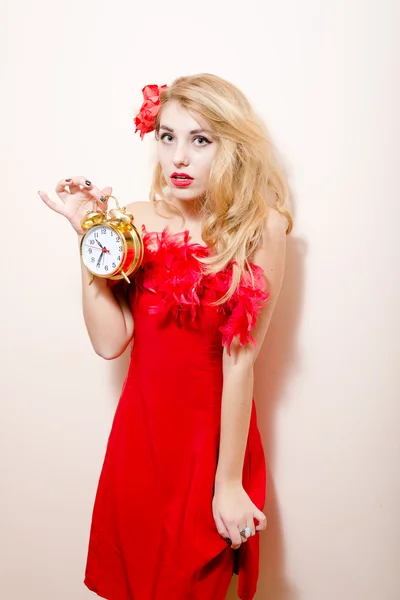 Mujer en vestido rojo sosteniendo alarma-reloj — Foto de Stock