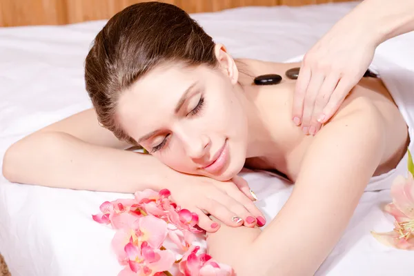 Closeup portrait of beautiful young woman having spa treatments: enjoying massage, stones therapy — Stock Photo, Image